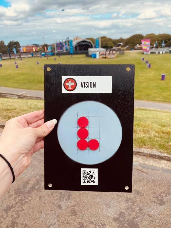 A board with red dots corresponding to the letter V in braille