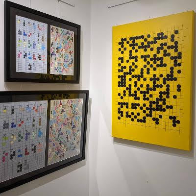 Picture frames with braille, one yellow board on the right and 2 black frames on the left.